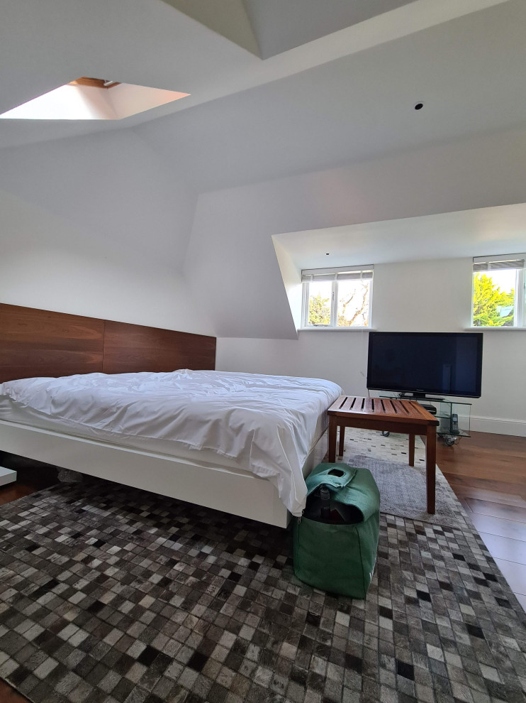 Mid-sized elegant master dark wood floor, brown floor and vaulted ceiling bedroom photo in Surrey with beige walls