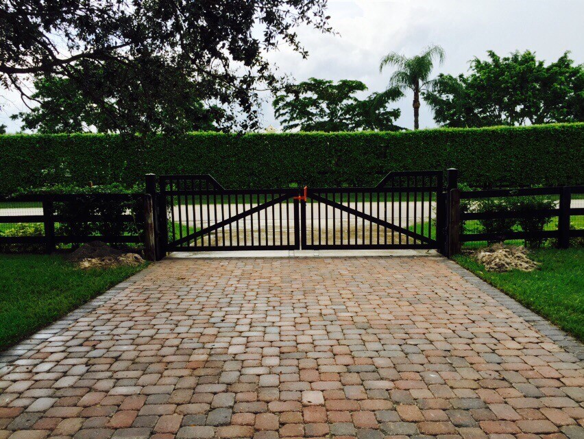 Large modern front yard driveway in Miami with brick pavers.