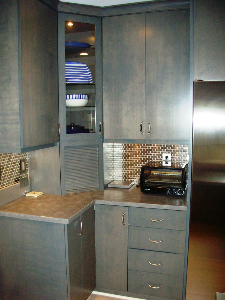 Photo of an eclectic kitchen in DC Metro with glass-front cabinets, blue cabinets, metallic splashback and metal splashback.