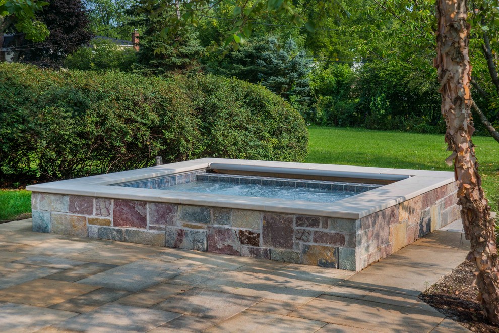 Inspiration for a small country backyard rectangular natural pool in Chicago with a hot tub and natural stone pavers.