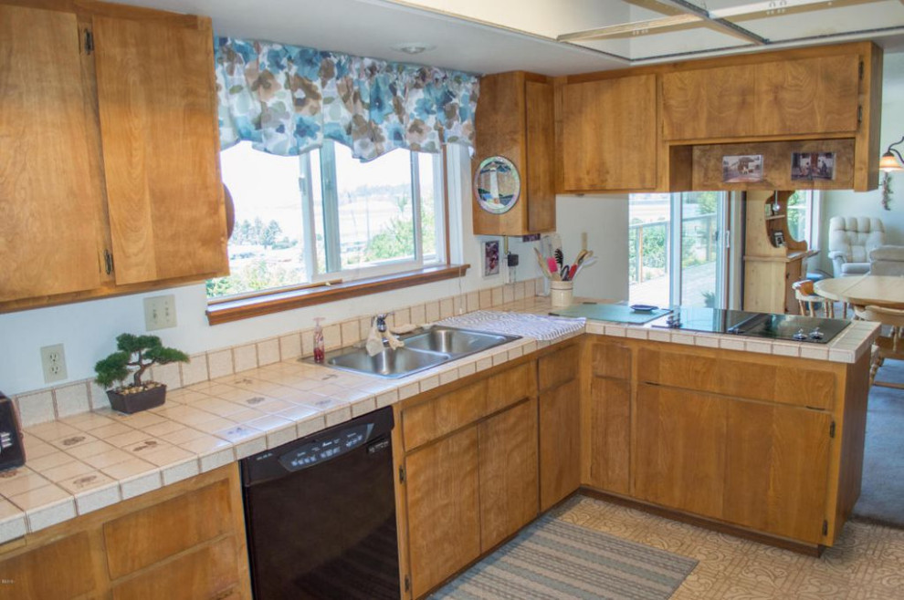 Foto på ett mellanstort funkis brun kök, med en nedsänkt diskho, vita skåp, träbänkskiva, beige stänkskydd, stänkskydd i trä, rostfria vitvaror, ljust trägolv och en halv köksö