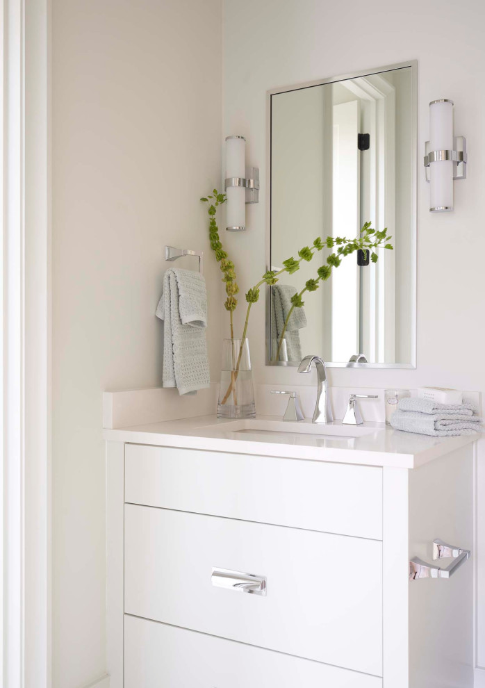 Photo of a transitional powder room in Charlotte with flat-panel cabinets, white cabinets, white walls, an undermount sink and white benchtops.