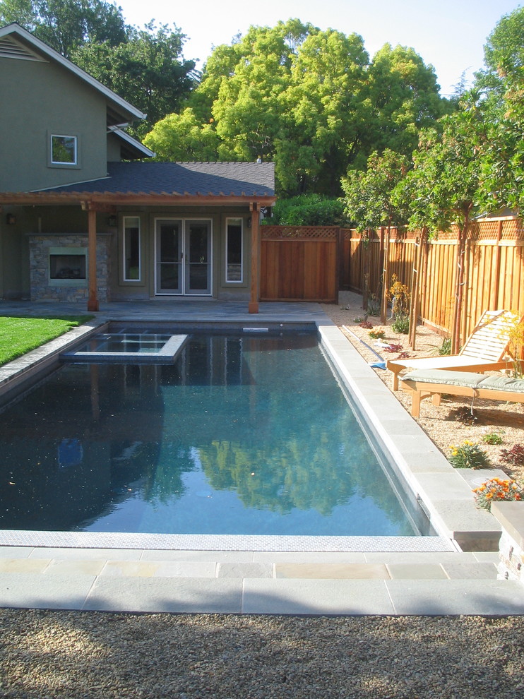 Photo of a mid-sized contemporary backyard rectangular lap pool in San Francisco with a hot tub and natural stone pavers.