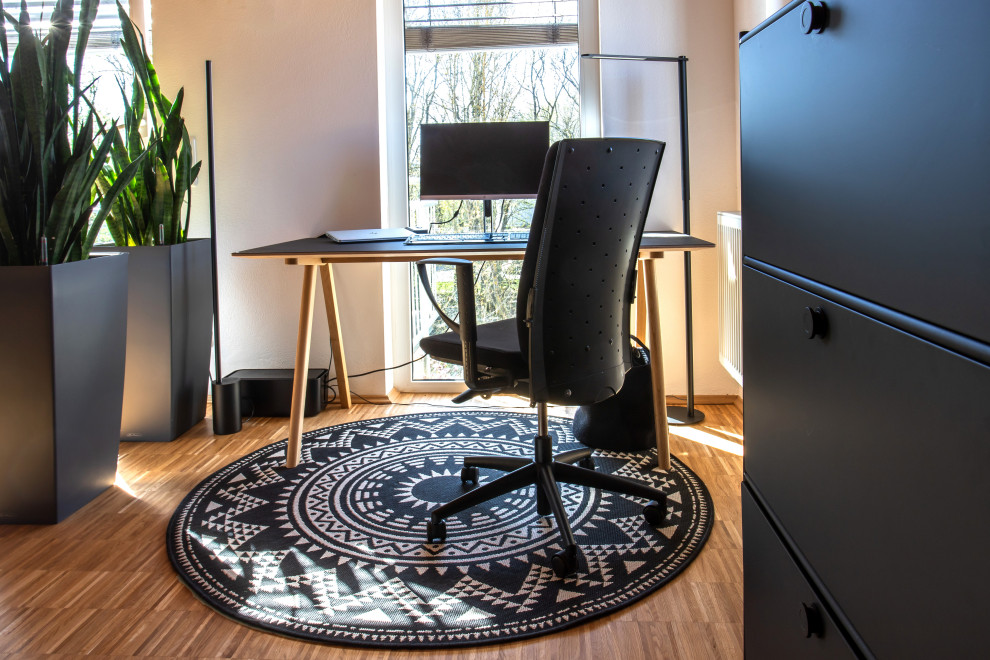 Réalisation d'un petit bureau nordique avec un sol en bois brun et un bureau indépendant.