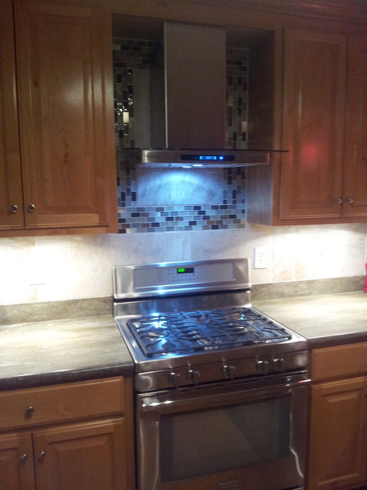 Example of a mid-sized classic galley kitchen design with metallic backsplash, glass tile backsplash and stainless steel appliances