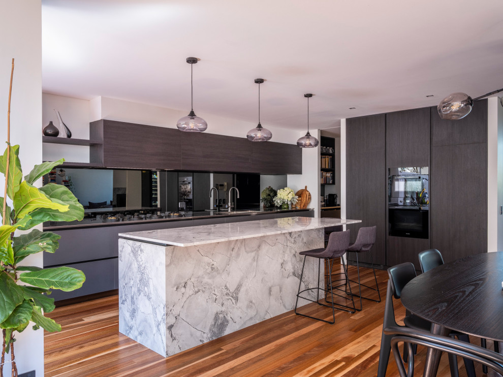 Inspiration for a large contemporary kitchen in Sydney with an undermount sink, open cabinets, stainless steel benchtops, mirror splashback, black appliances and brown floor.