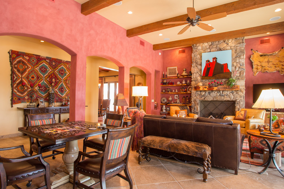 Mid-sized open concept living room in Phoenix with red walls, limestone floors, a standard fireplace, a stone fireplace surround, a wall-mounted tv and beige floor.