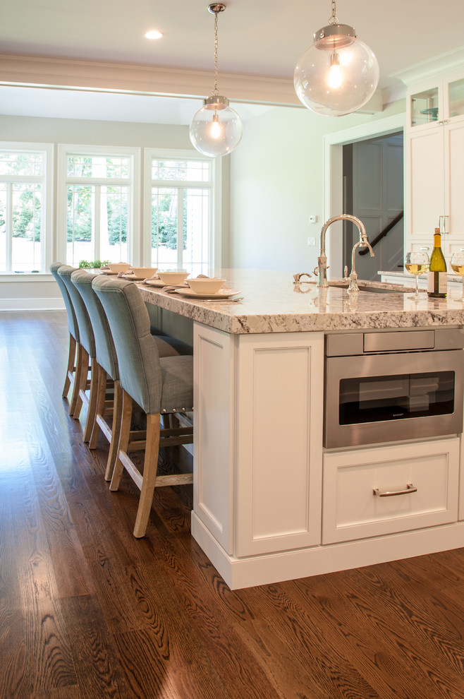 Example of a large transitional eat-in kitchen design in New York with shaker cabinets, white cabinets and an island