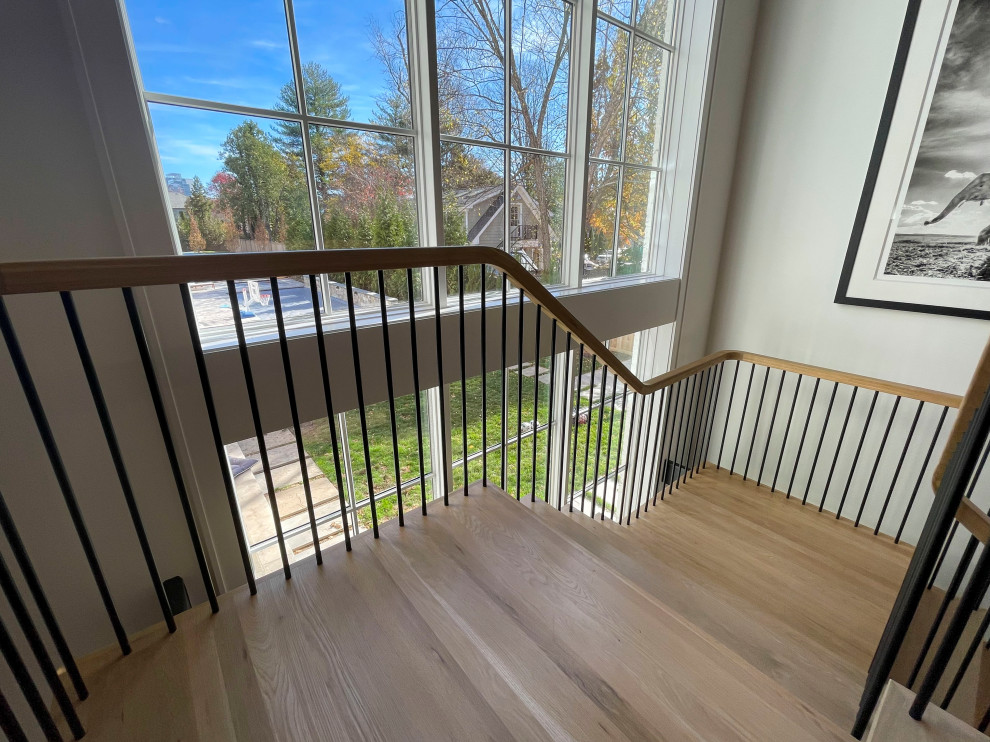 Imagen de escalera suspendida minimalista extra grande con escalones de madera, barandilla de varios materiales y machihembrado