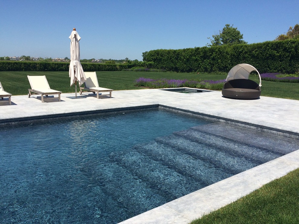 Example of a large backyard stone and rectangular lap hot tub design in New York