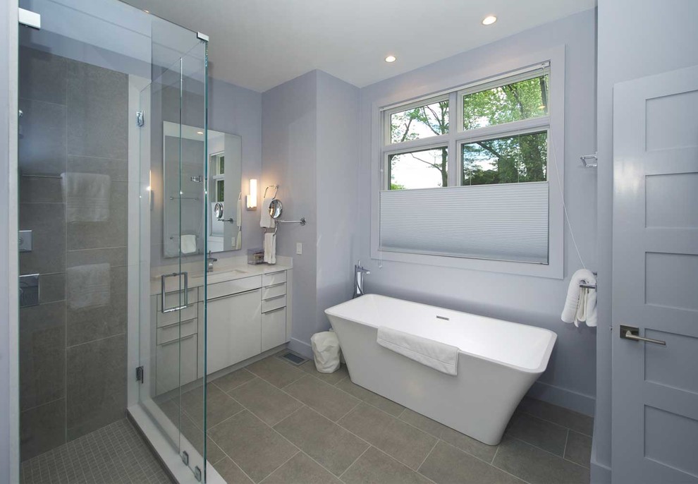 Inspiration for a mid-sized contemporary master bathroom in Boston with flat-panel cabinets, white cabinets, a freestanding tub, a corner shower, gray tile and grey walls.