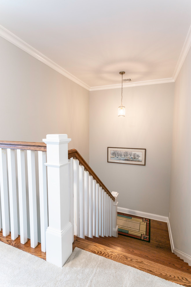 This is an example of a mid-sized modern wood l-shaped staircase in Charleston with wood risers and wood railing.