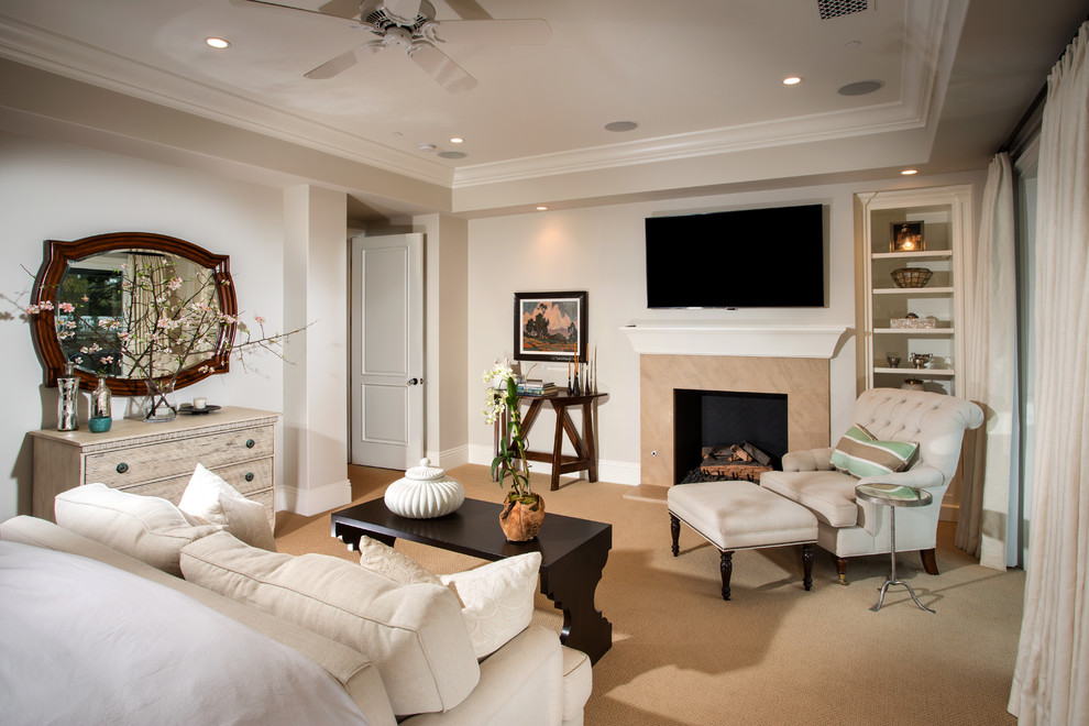 Photo of a large traditional master bedroom in Orange County with grey walls, carpet, a standard fireplace, a stone fireplace surround and brown floor.