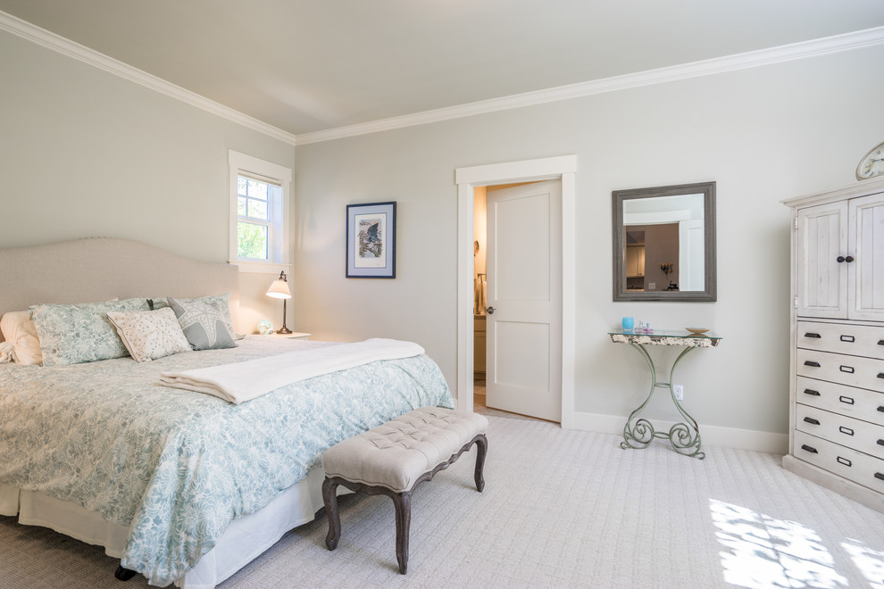 This is an example of a large beach style master bedroom in Seattle with beige walls and carpet.