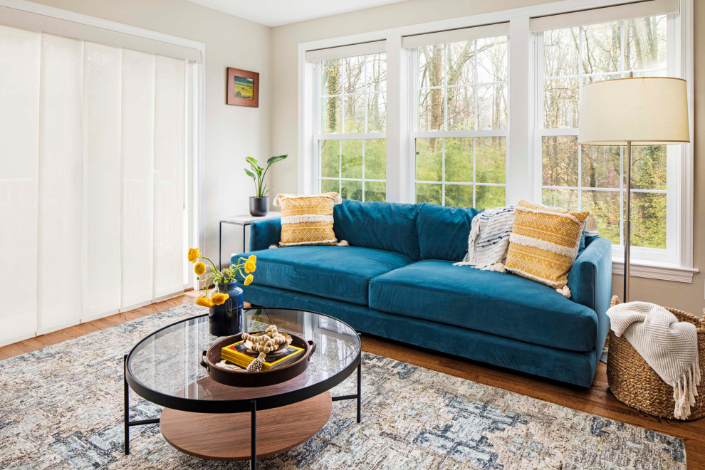 Пример оригинального дизайна: открытая гостиная комната в современном стиле с белыми стенами, паркетным полом среднего тона, коричневым полом и синим диваном