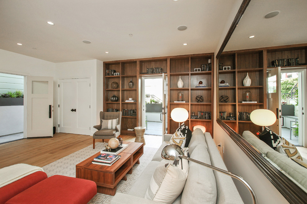Large contemporary open concept family room in San Francisco with white walls and light hardwood floors.
