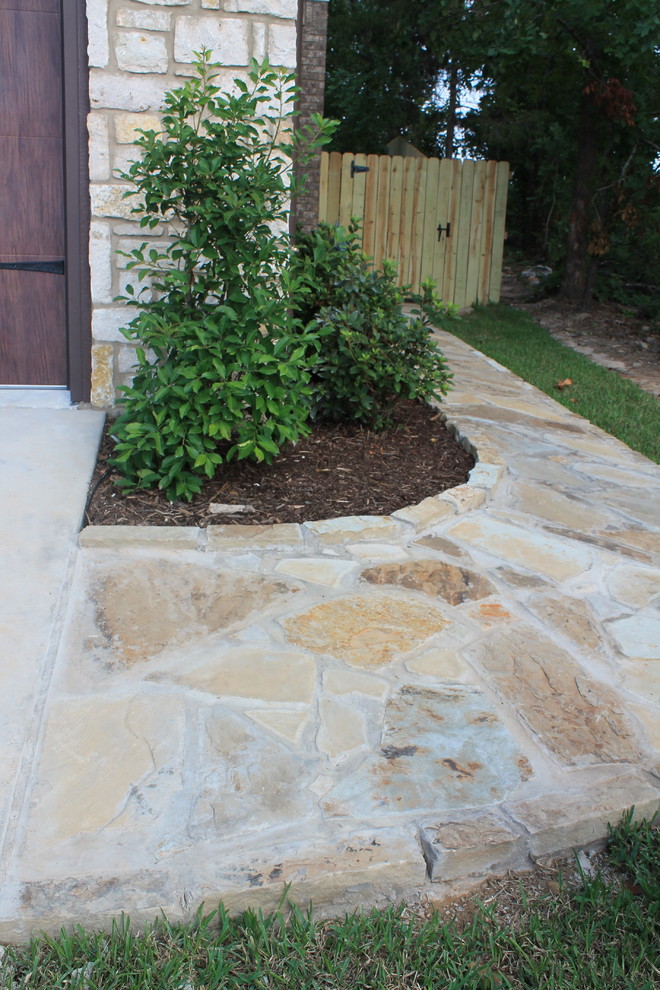Photo of a mid-sized transitional front yard full sun garden in Dallas with a garden path and natural stone pavers.
