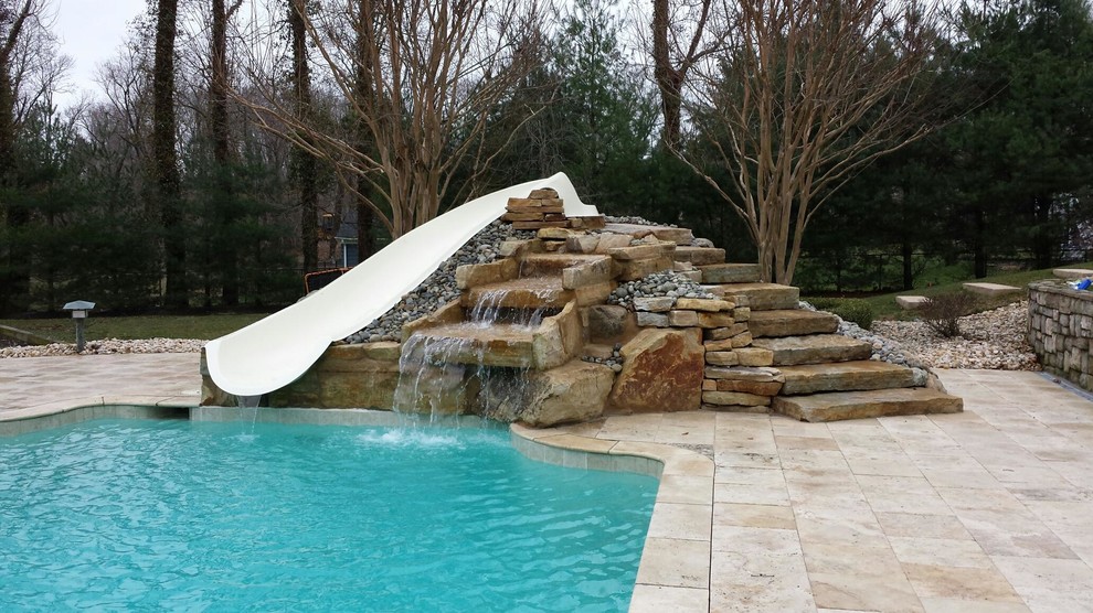 Large transitional backyard rectangular pool in New York with a water slide and concrete pavers.