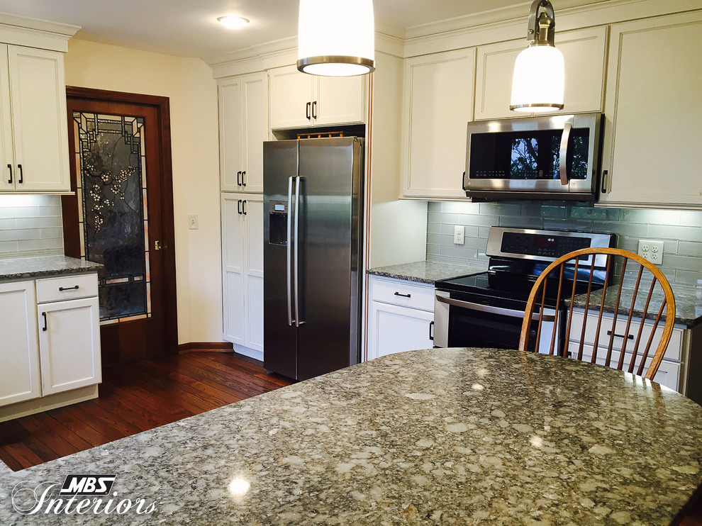 Inspiration for a transitional u-shaped enclosed kitchen remodel with an undermount sink, flat-panel cabinets, white cabinets, quartz countertops, gray backsplash, subway tile backsplash, stainless steel appliances and a peninsula