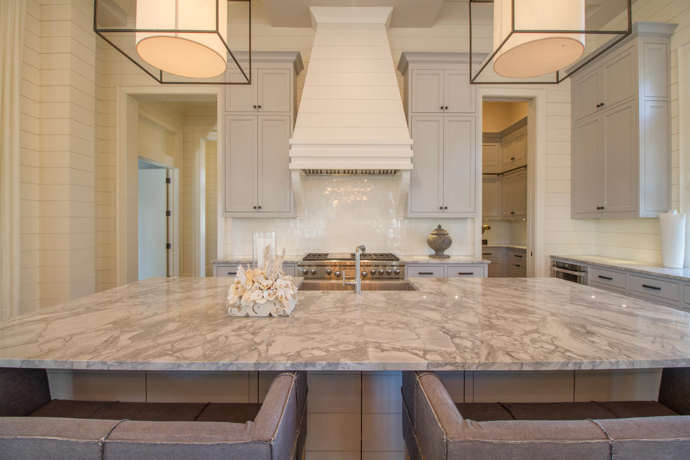 This is an example of a beach style l-shaped open plan kitchen in Miami with a farmhouse sink, shaker cabinets, white cabinets, dark hardwood floors and with island.