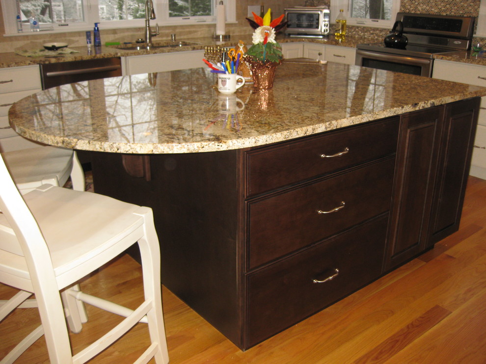 Transitional l-shaped light wood floor eat-in kitchen photo in Boston with granite countertops, stainless steel appliances, an island, an undermount sink, raised-panel cabinets, white cabinets, beige backsplash and ceramic backsplash