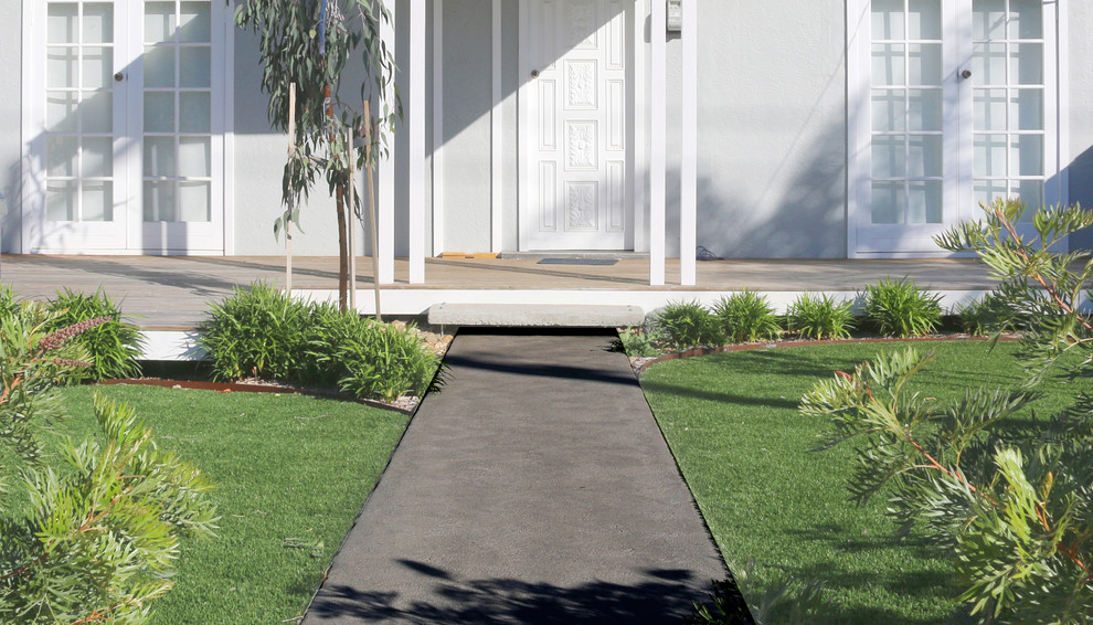 This is an example of a mid-sized and australian native modern front yard full sun xeriscape for summer in Melbourne with a garden path and concrete pavers.