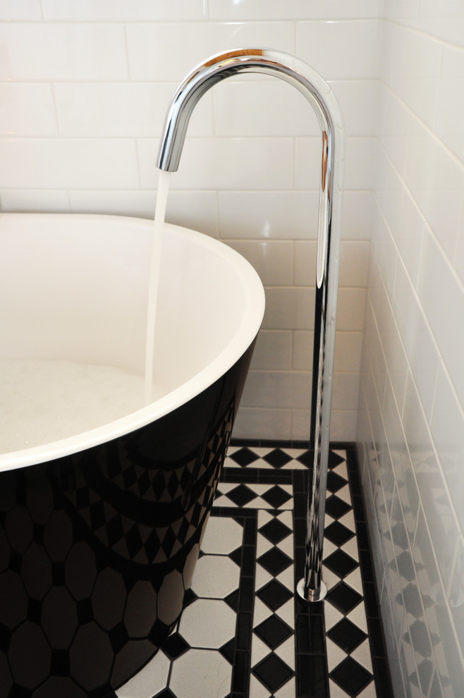 Inspiration for a mid-sized traditional master bathroom in Melbourne with black cabinets, a freestanding tub, black and white tile, porcelain tile, white walls, porcelain floors, a vessel sink and quartzite benchtops.