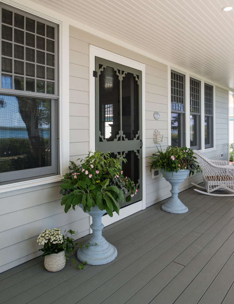 This is an example of a large beach style front yard verandah in Other with decking and a roof extension.