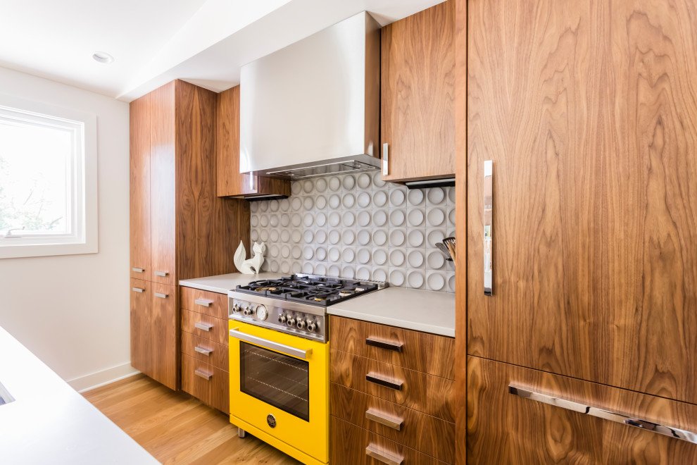 This is an example of a contemporary eat-in kitchen in Other with brown floor, medium wood cabinets, coloured appliances and grey benchtop.