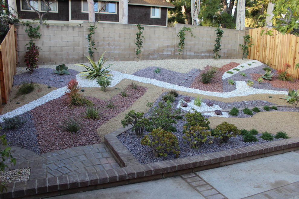 This is an example of a mid-sized transitional sloped partial sun formal garden in Orange County with gravel and a vertical garden.