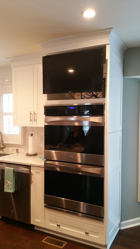 Eat-in kitchen - transitional galley eat-in kitchen idea with an undermount sink, shaker cabinets, white cabinets, marble countertops, white backsplash, subway tile backsplash, stainless steel appliances, an island and gray countertops