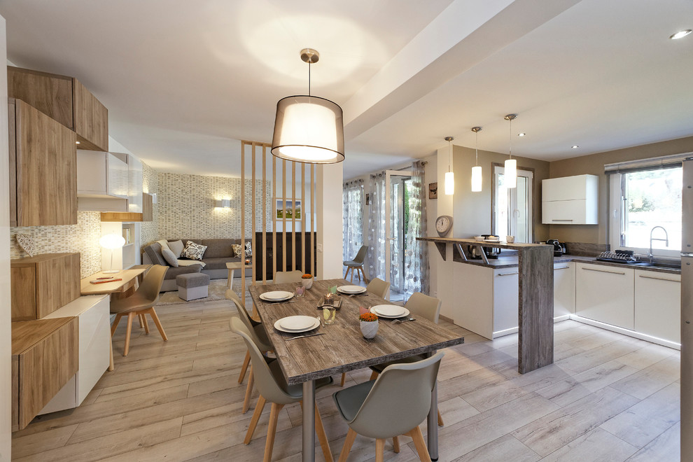 Cette photo montre une grande salle de séjour scandinave ouverte avec un téléviseur indépendant, un mur beige, sol en stratifié, aucune cheminée et un sol beige.