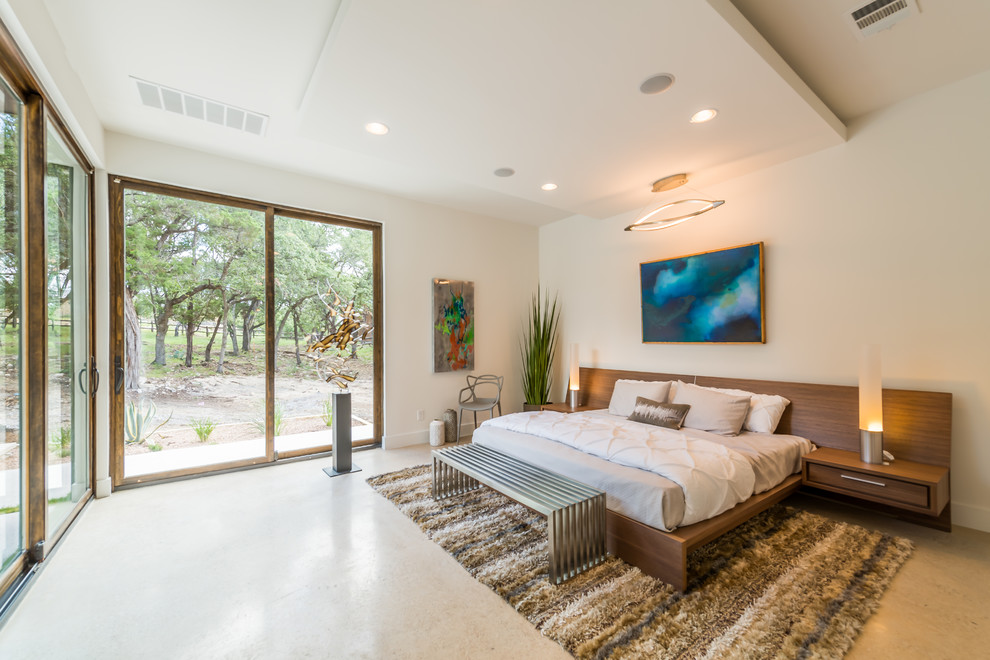Design ideas for a contemporary bedroom in Austin with white walls and concrete floors.