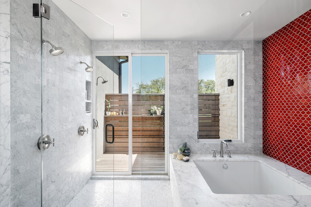 This is an example of a large contemporary master wet room bathroom in Austin with an undermount tub, red tile, ceramic tile, red walls, mosaic tile floors, marble benchtops, grey floor and a hinged shower door.