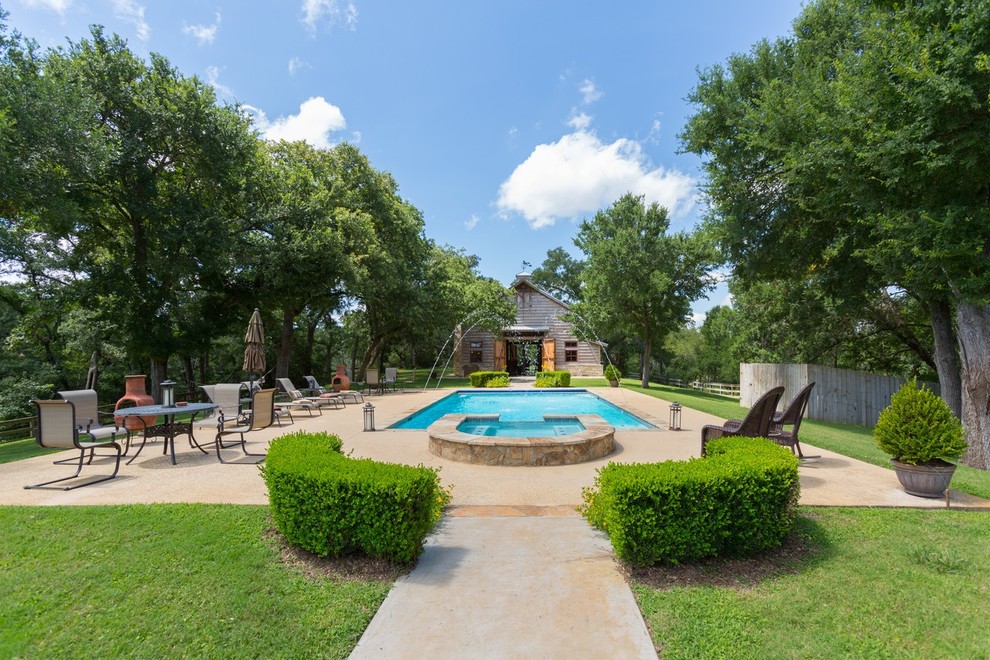 Inspiration for a mid-sized front yard rectangular pool in Houston with a water feature and concrete slab.