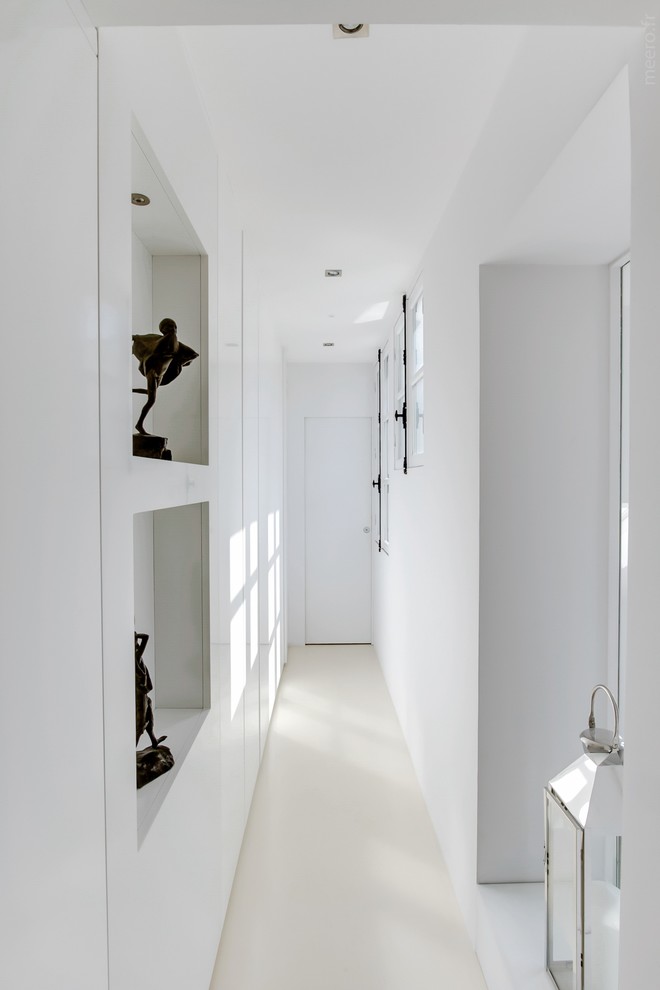 Photo of a mid-sized contemporary hallway in Paris with white walls.