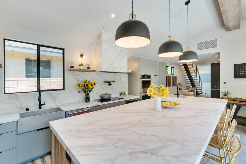 Foto på ett stort funkis flerfärgad kök, med en rustik diskho, släta luckor, blå skåp, marmorbänkskiva, flerfärgad stänkskydd, stänkskydd i marmor, rostfria vitvaror, betonggolv, en köksö och grått golv