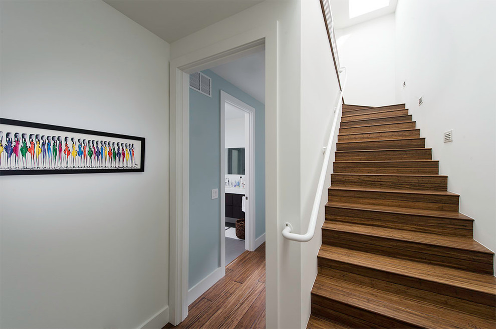 Mid-sized contemporary wood u-shaped staircase in Cleveland with wood risers and metal railing.