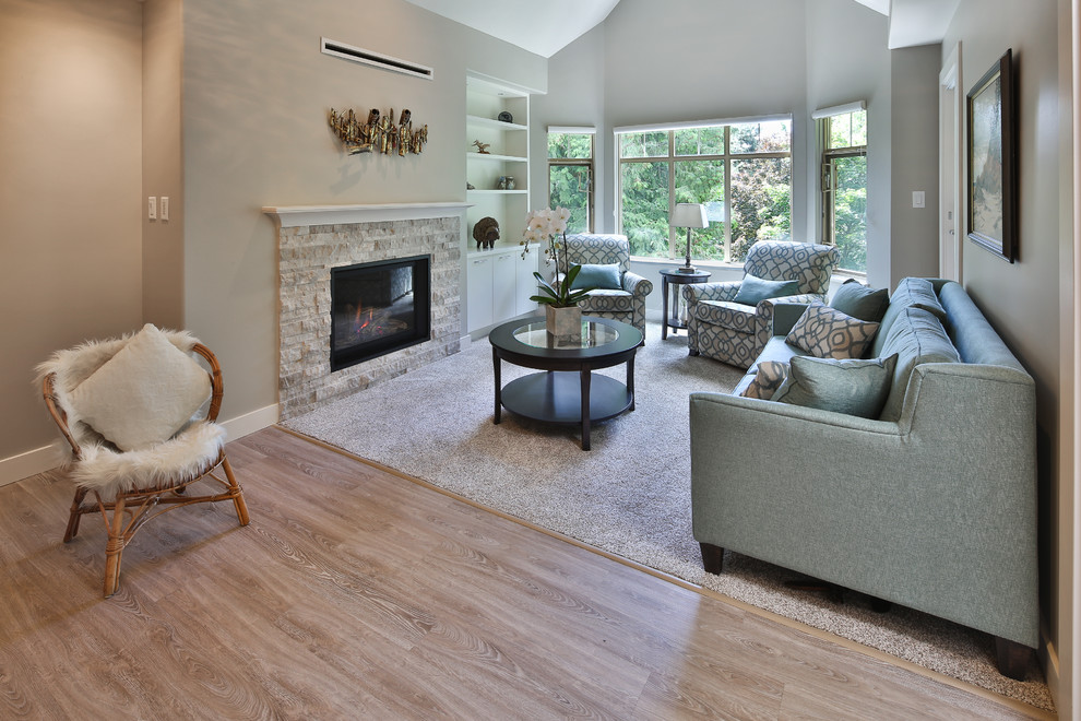 Photo of a small contemporary open concept living room in Other with grey walls, carpet, a standard fireplace, a stone fireplace surround and beige floor.