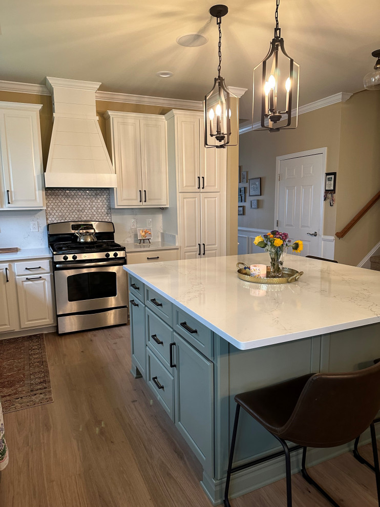 Example of a mid-sized classic l-shaped vinyl floor and beige floor eat-in kitchen design with an undermount sink, raised-panel cabinets, white cabinets, quartz countertops, beige backsplash, quartz backsplash, stainless steel appliances, an island and beige countertops