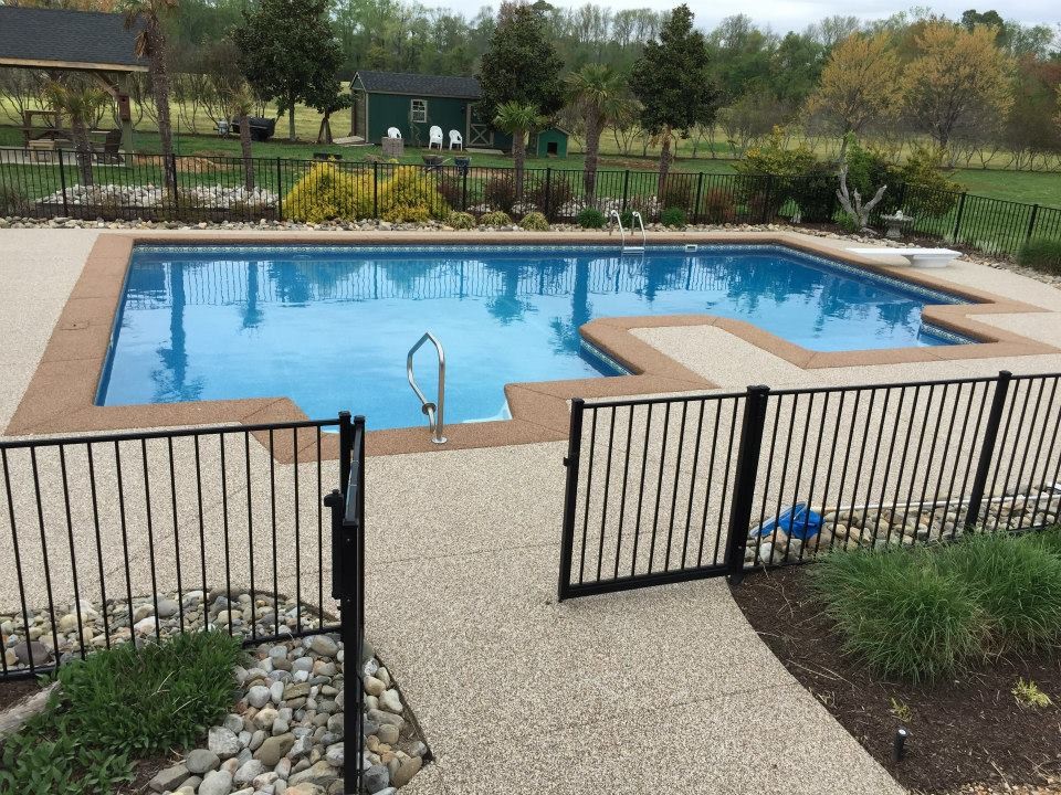 Example of a mid-sized transitional backyard concrete and custom-shaped pool design