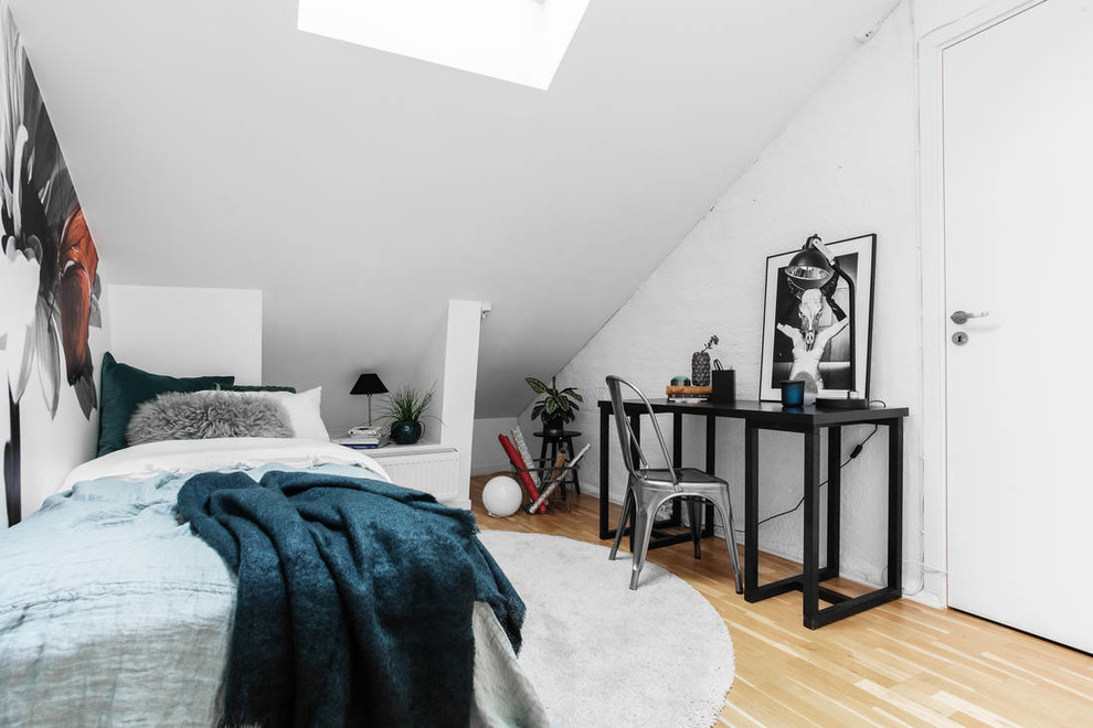 Photo of a scandinavian bedroom in Stockholm with white walls, light hardwood floors and brown floor.