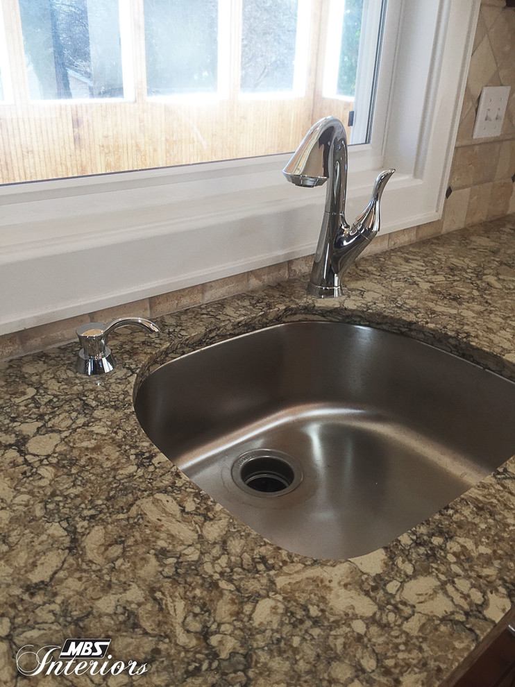 Eat-in kitchen - large transitional medium tone wood floor eat-in kitchen idea in Cincinnati with an undermount sink, recessed-panel cabinets, dark wood cabinets, quartz countertops, beige backsplash, stone tile backsplash, stainless steel appliances and an island