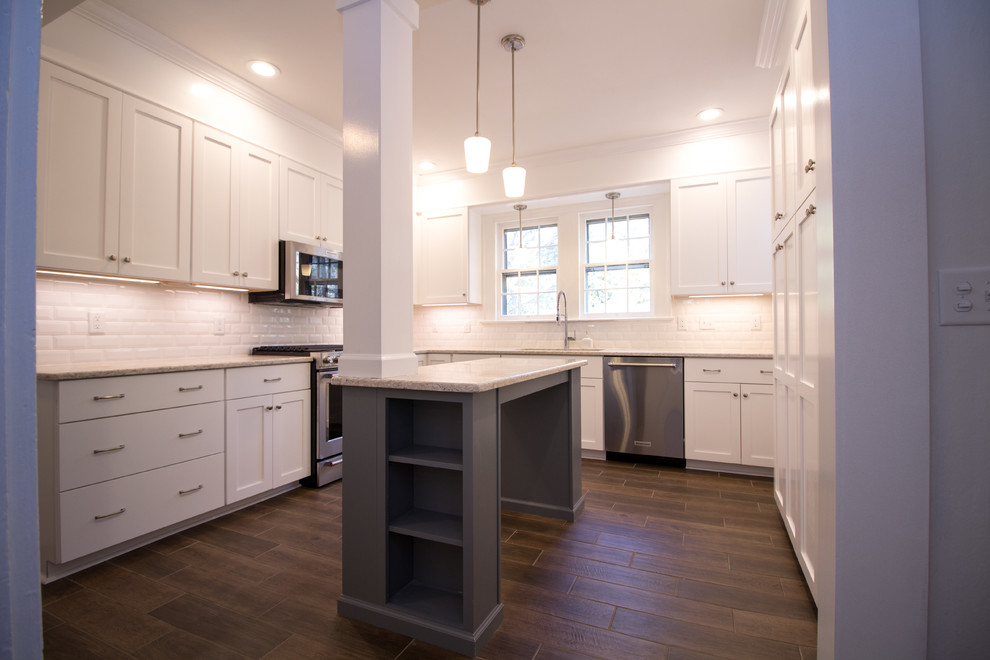 Example of a small u-shaped ceramic tile eat-in kitchen design with an undermount sink, shaker cabinets, white cabinets, quartz countertops, white backsplash, subway tile backsplash, stainless steel appliances, an island and white countertops