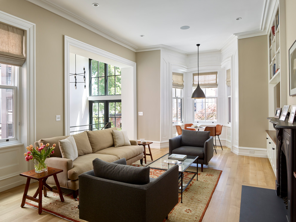 Transitional family room in Philadelphia with beige walls, medium hardwood floors, a standard fireplace and brown floor.