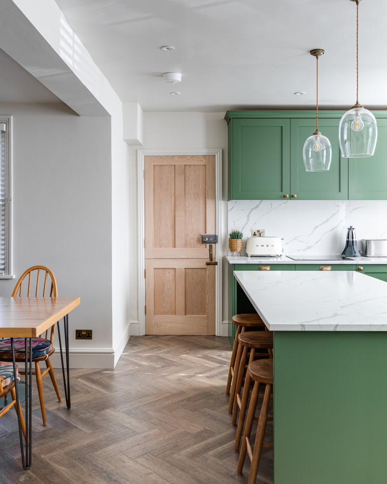 Large classic u-shaped kitchen/diner in Hertfordshire with shaker cabinets, green cabinets, quartz worktops and an island.