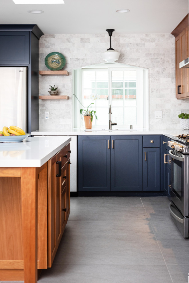 Enclosed kitchen - mid-sized transitional l-shaped ceramic tile and gray floor enclosed kitchen idea in Orange County with an undermount sink, shaker cabinets, blue cabinets, quartz countertops, gray backsplash, marble backsplash, stainless steel appliances, an island and white countertops