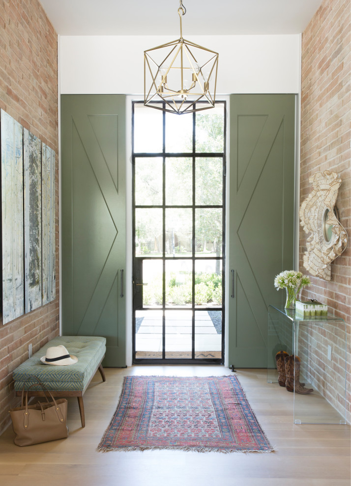 Design ideas for a transitional foyer in Austin with white walls, medium hardwood floors, a single front door, a glass front door, brown floor and wallpaper.