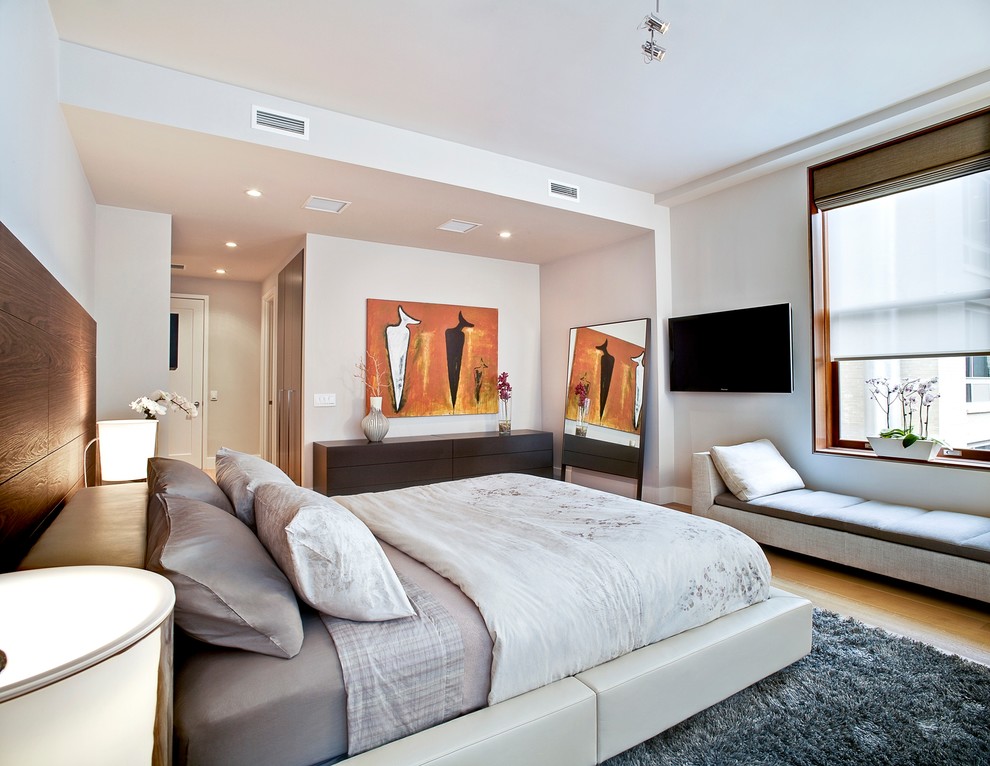 Design ideas for a contemporary bedroom in New York with beige walls, light hardwood floors, no fireplace and beige floor.