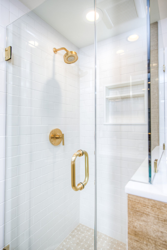 Photo of a large contemporary 3/4 bathroom in Philadelphia with shaker cabinets, white cabinets, a corner shower, a two-piece toilet, white tile, subway tile, brown walls, porcelain floors, an undermount sink, marble benchtops, beige floor, a hinged shower door and beige benchtops.